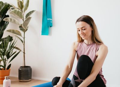 A water bottle and a towel resting on a wooden floor.